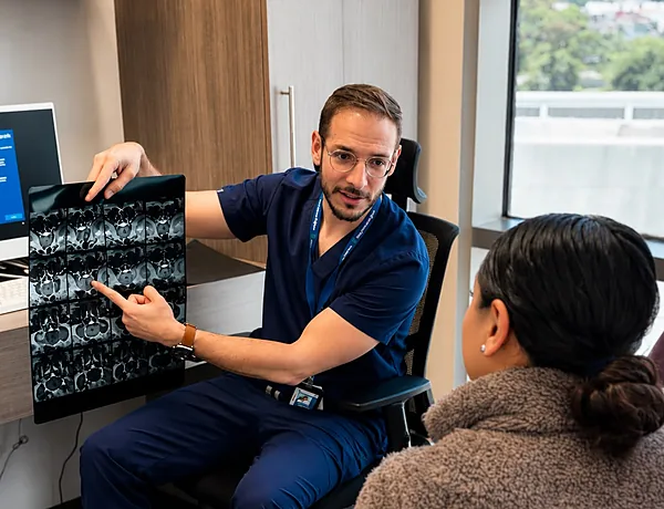 Dr. Héctor Morán explicando estudios a una paciente — diagnóstico de fisura anal en CDMX
